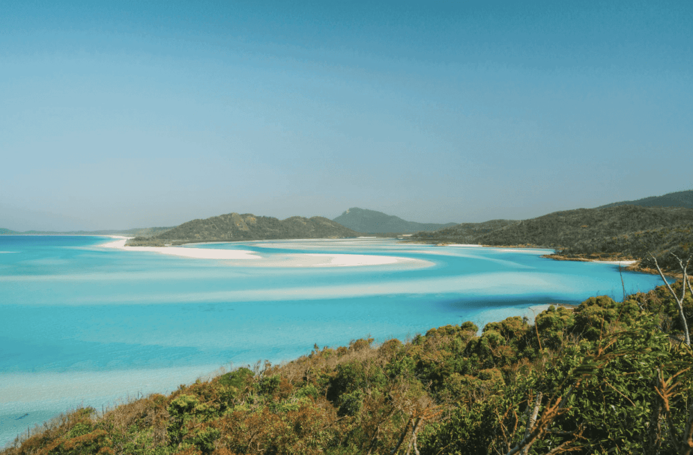 Swirling Sands of Whitehaven Beach in the Whitsundays in the middle of the glorious aqua blue coral sea water