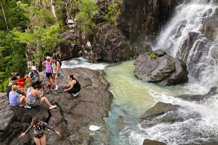 a group of people riding on the back of a waterfall