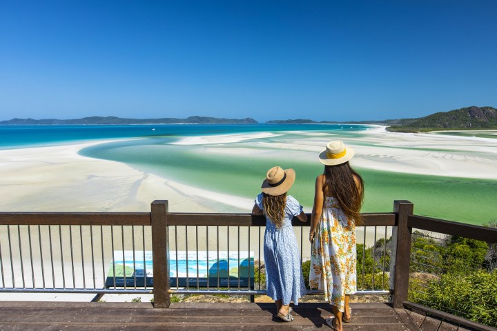a person sitting on a bench in front of a body of water