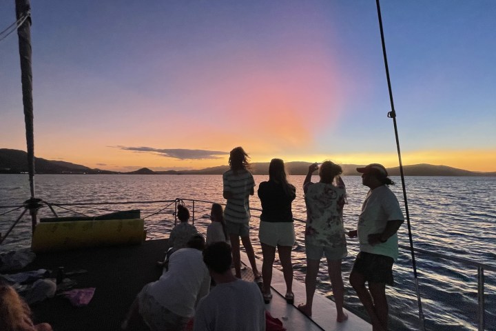a group of people standing next to a body of water