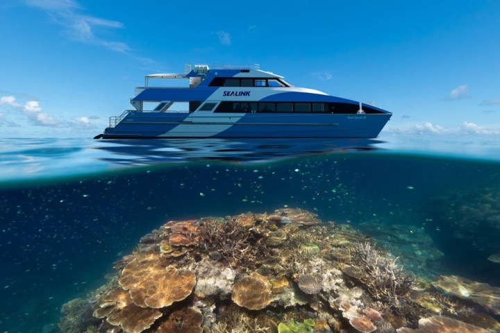 a blue and white boat sitting next to a body of water