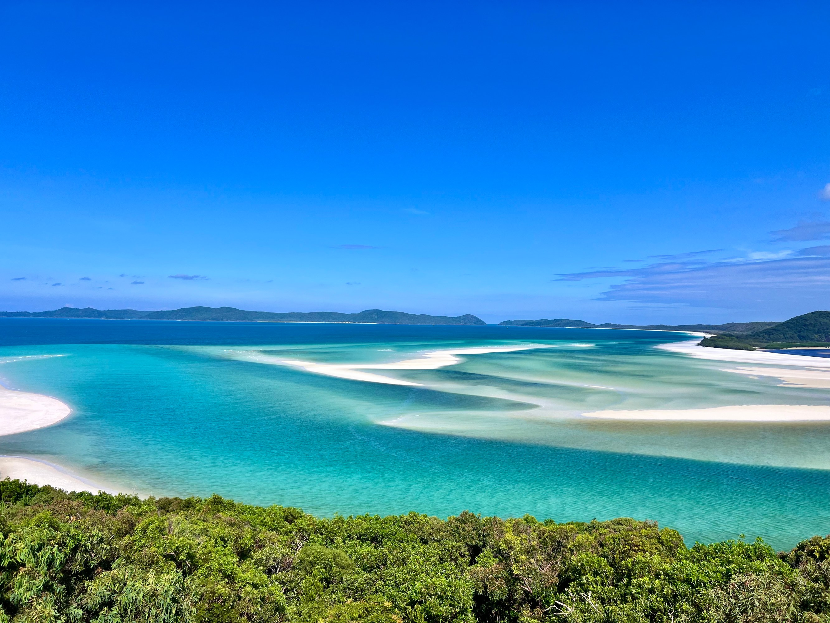 a sandy beach next to a body of water
